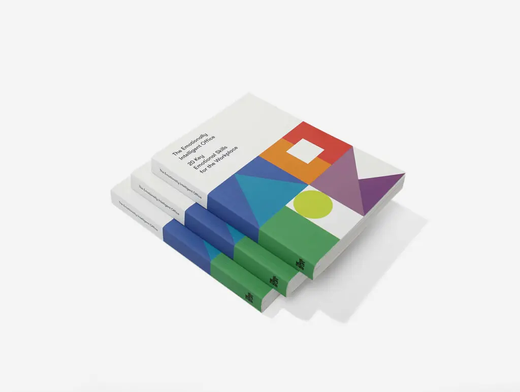 Three stacked copies of a book titled *The Emotionally Intelligent Office*, featuring a white cover with bold, colourful geometric shapes and a green and blue spine, placed on a clean white background.