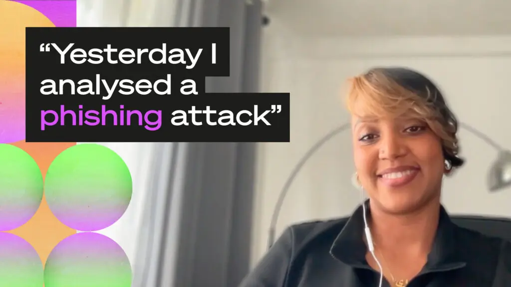 A person smiles at the camera during a video call, wearing earbuds and a dark zip-up jacket with a gold necklace. Overlaid text reads: "Yesterday I analysed a phishing attack" with "phishing" highlighted in purple. The left side features a colorful graphic with overlapping circles in green, orange, and purple.