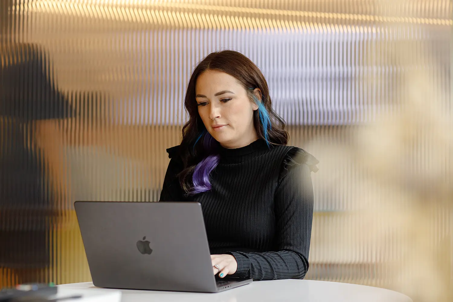 Female working on Apple mac laptop at desk